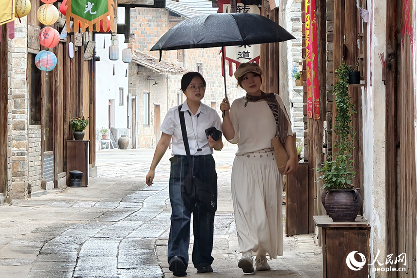游客在雨中漫步，享受慢生活帶來的靜謐時光。人民網記者 時雨攝