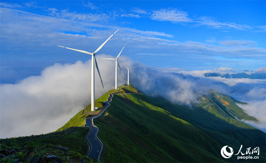 贛州市上猶縣雙溪草山云蒸霞蔚，一臺臺風力發電機迎風旋轉，與延綿群山相映成景，壯美如畫。人民網 朱海鵬攝