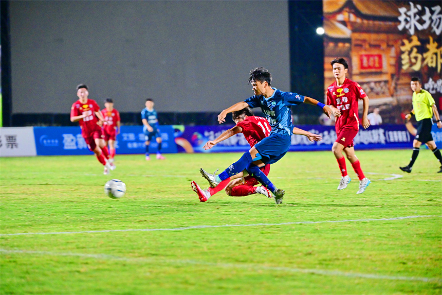 身穿紅色球員的宜春隊球員和身穿藍色球衣的景德鎮球員在綠茵場上激烈拼搶。劉勇攝