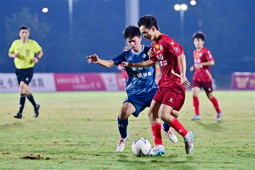 身穿紅色球員的宜春隊球員和身穿藍色球衣的景德鎮球員在綠茵場上激烈拼搶。劉勇攝