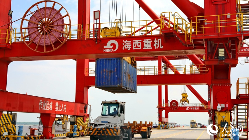 九江市彭澤縣的九江紅光國際港，碼頭貨輪穿梭，工人堅守崗位一線，集裝箱裝卸作業有序進行。人民網 朱海鵬攝