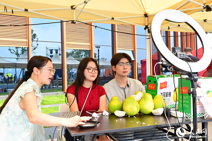 活動現場，參加網絡直播銷售擂臺賽的主播們通過直播助力井岡蜜柚銷售。人民網 朱海鵬攝