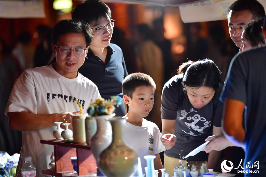 游客在春秋大集的攤位上挑選心儀的瓷器。人民網記者 時雨攝