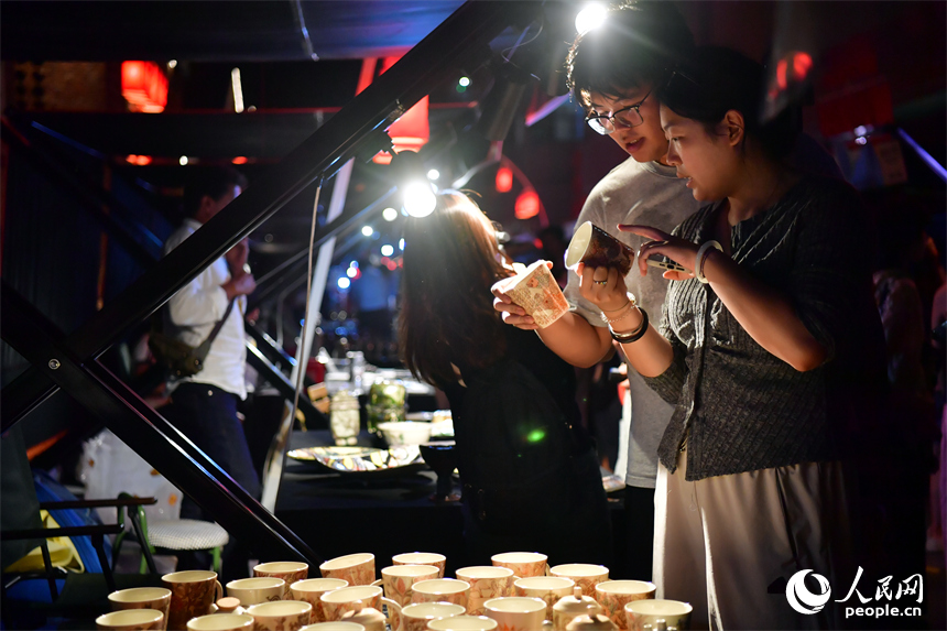 游客在春秋大集的攤位上挑選心儀的瓷器。人民網記者 時雨攝