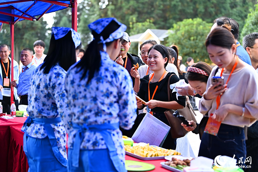 采購商和游客前來洽談臍橙訂單，品嘗臍橙特色美食。人民網 朱海鵬攝