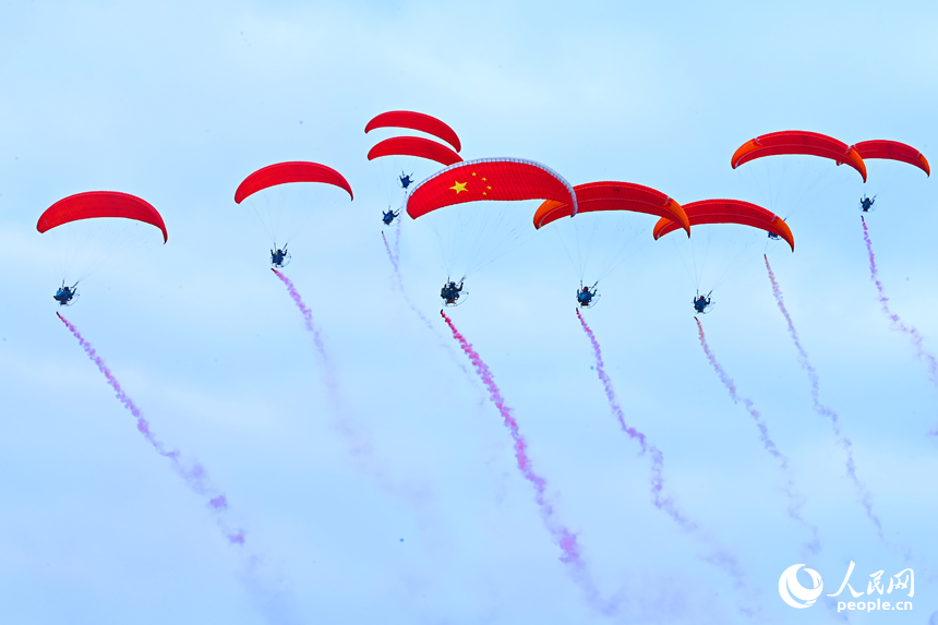 南康區龍回鎮布谷寨航空飛行營地，動力傘編隊、滑翔傘表演和比賽吸引眾多游客前來觀看。人民網記者 朱海鵬攝