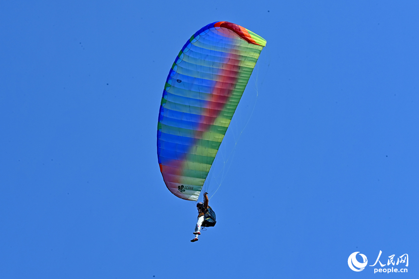 南康區龍回鎮布谷寨航空飛行營地，動力傘編隊、滑翔傘表演和比賽吸引眾多游客前來觀看。人民網記者 朱海鵬攝