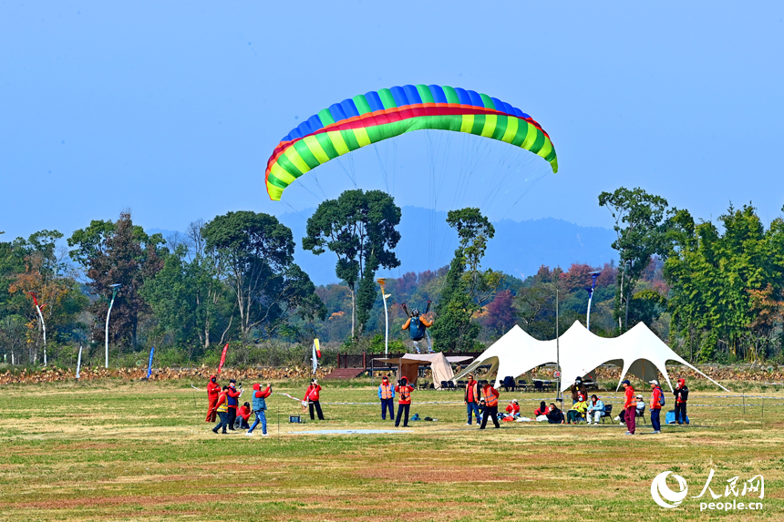南康區龍回鎮布谷寨航空飛行營地，動力傘編隊、滑翔傘表演和比賽吸引眾多游客前來觀看。人民網記者 朱海鵬攝